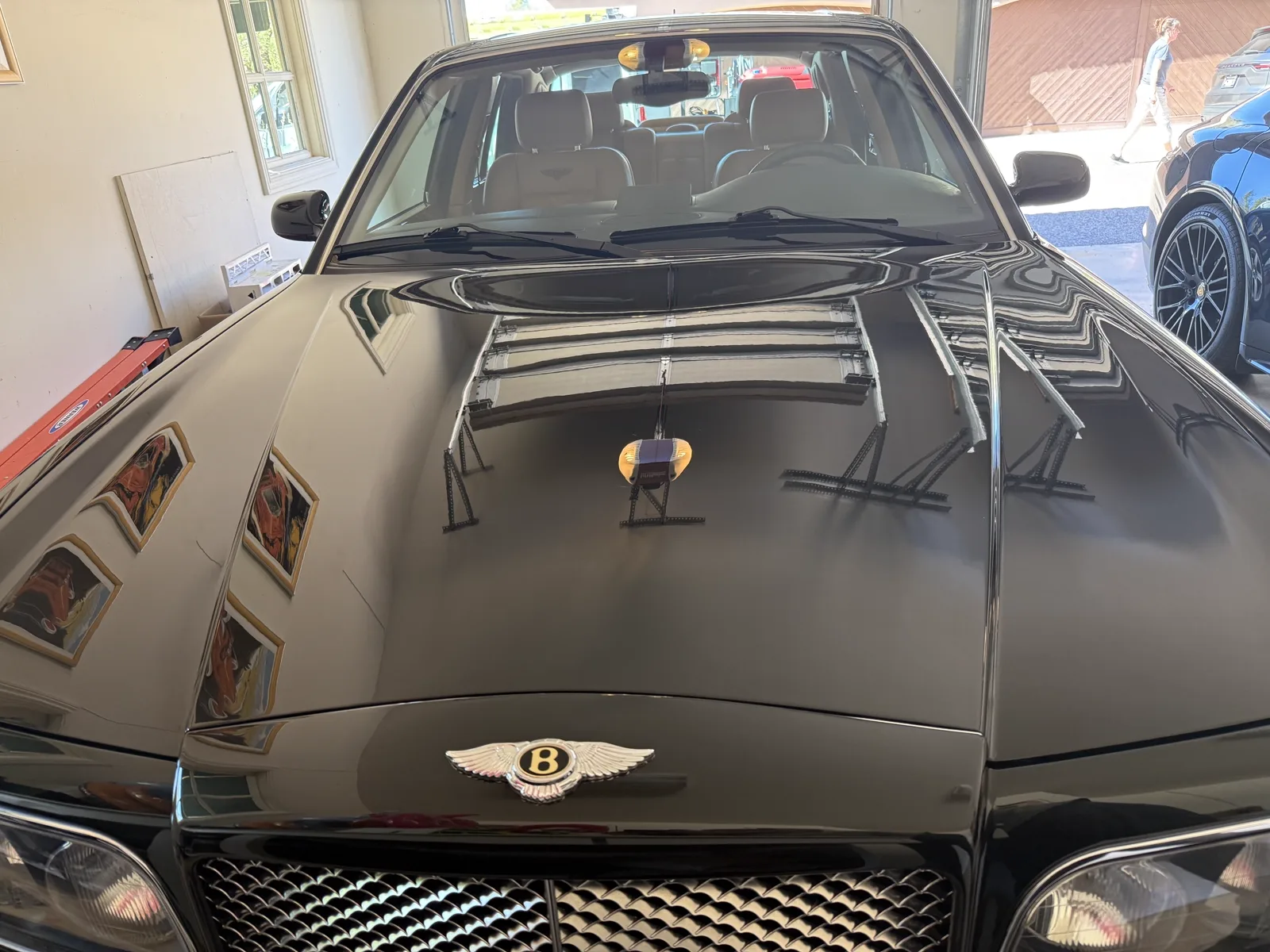 Mirror-gloss black Bentley hood after machine paint correction in a Scottsdale garage