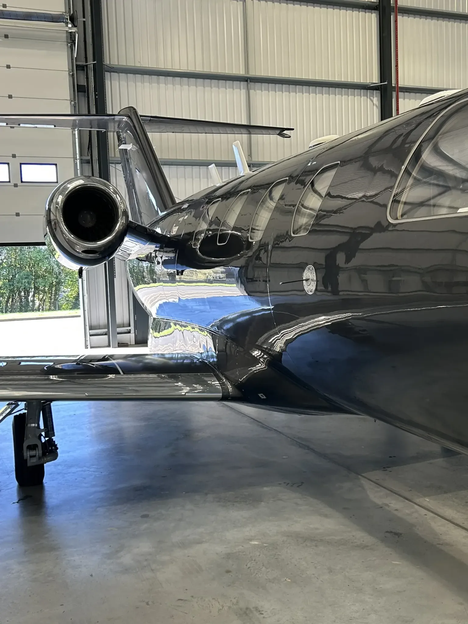 Glossy protected jet exterior reflecting the hangar