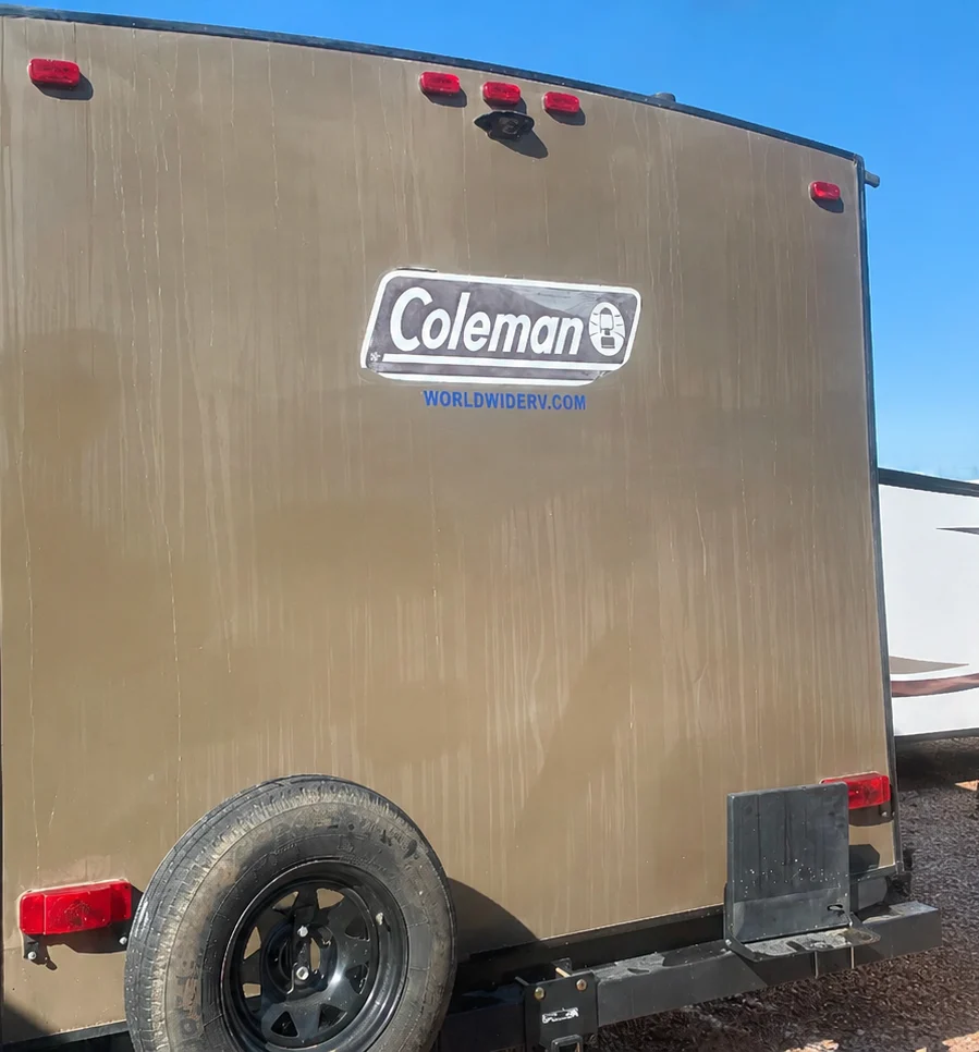 Oxidized fiberglass rear cap on a Coleman travel trailer before gel coat restoration